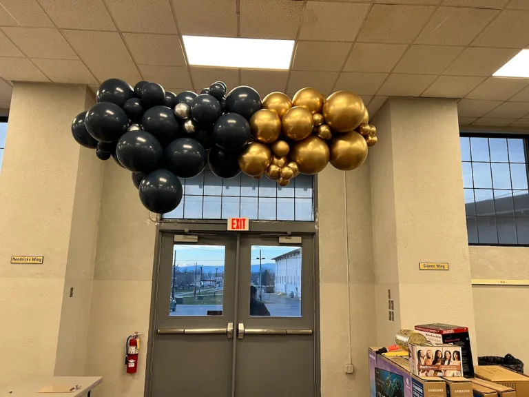 Dark navy and gold balloon garland over the entrance doors at the Costco holiday celebration in Frederick, MD