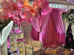 Pink balloon arch over the dessert table at the BWI quinceañera