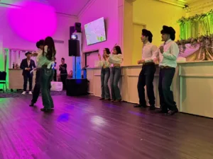 Couples dancing with young men in cowboy hats at Jimena's quinceañera in Silver Spring, MD
