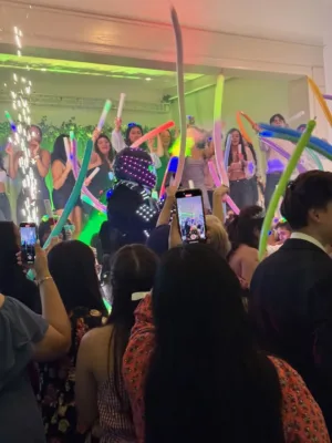 Guests dancing with colorful foam glow sticks around an LED robot performer at Jimena's quinceañera in Silver Spring, MD