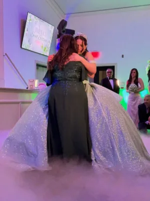Quinceañera Jimena in a sparkling gown and tiara embracing a guest at her quinceañera celebration in Silver Spring, MD